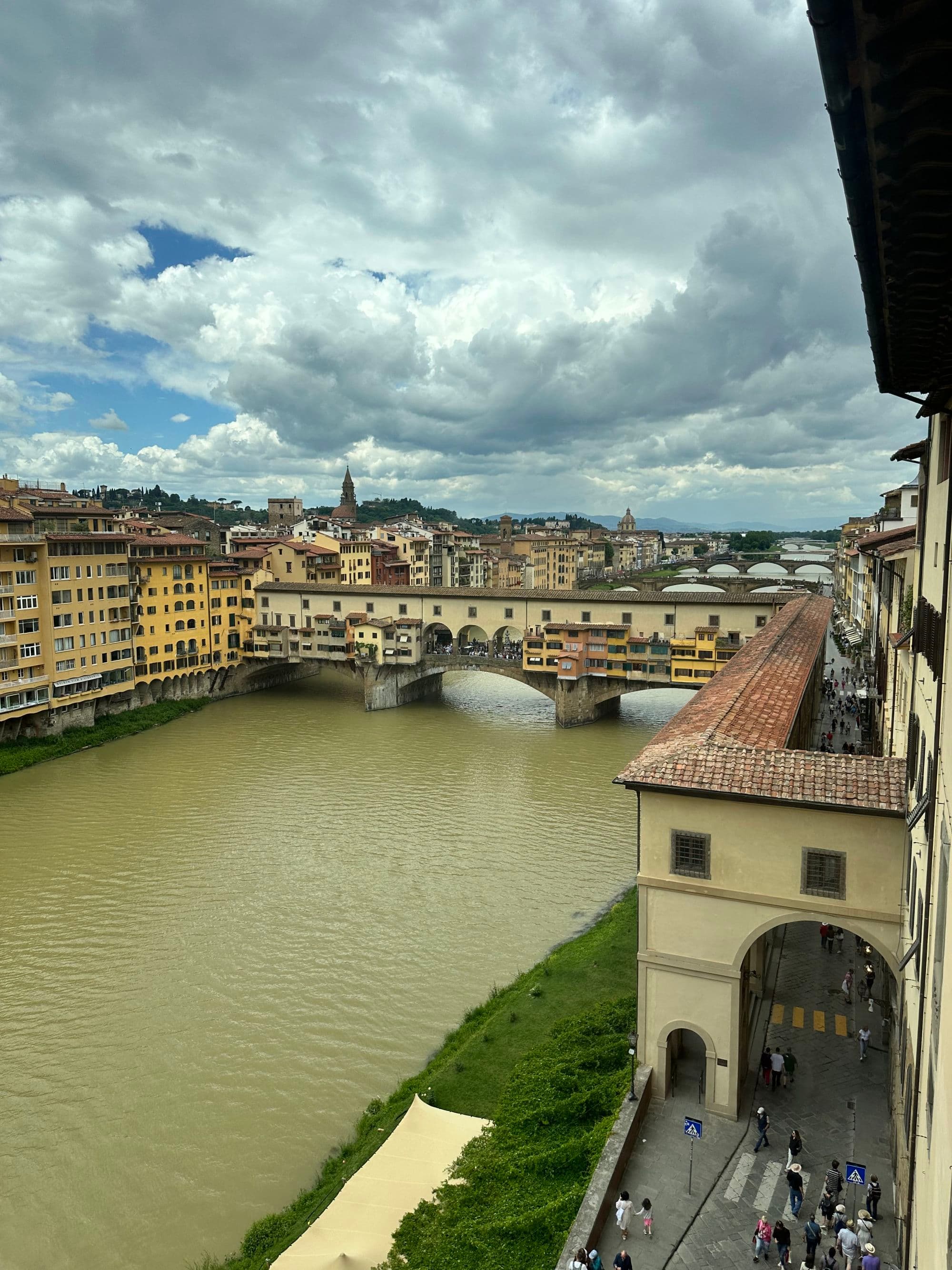 Bridge across a river with colorful Italian buildings.