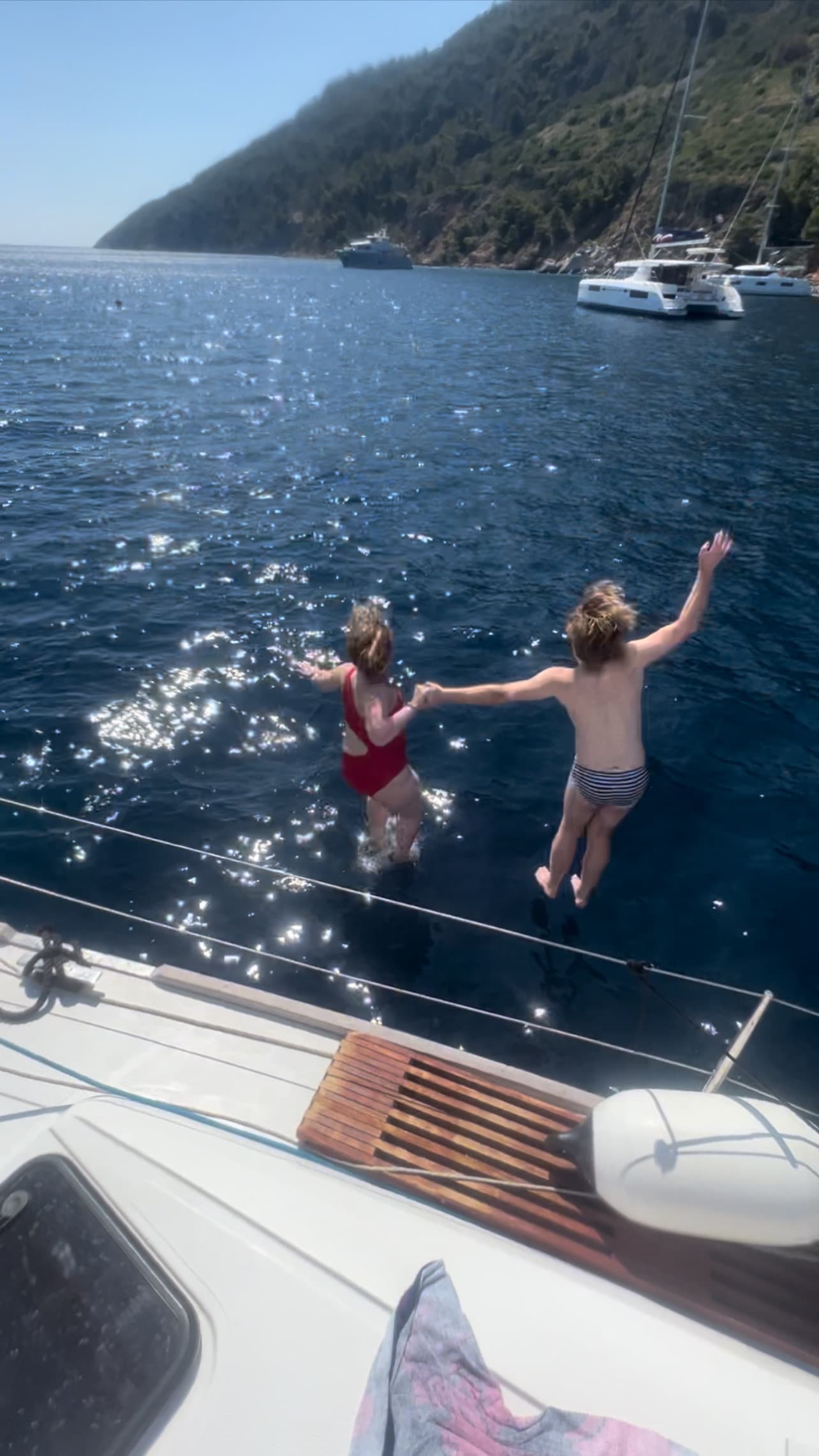 Two people jumping in the sea from cruise