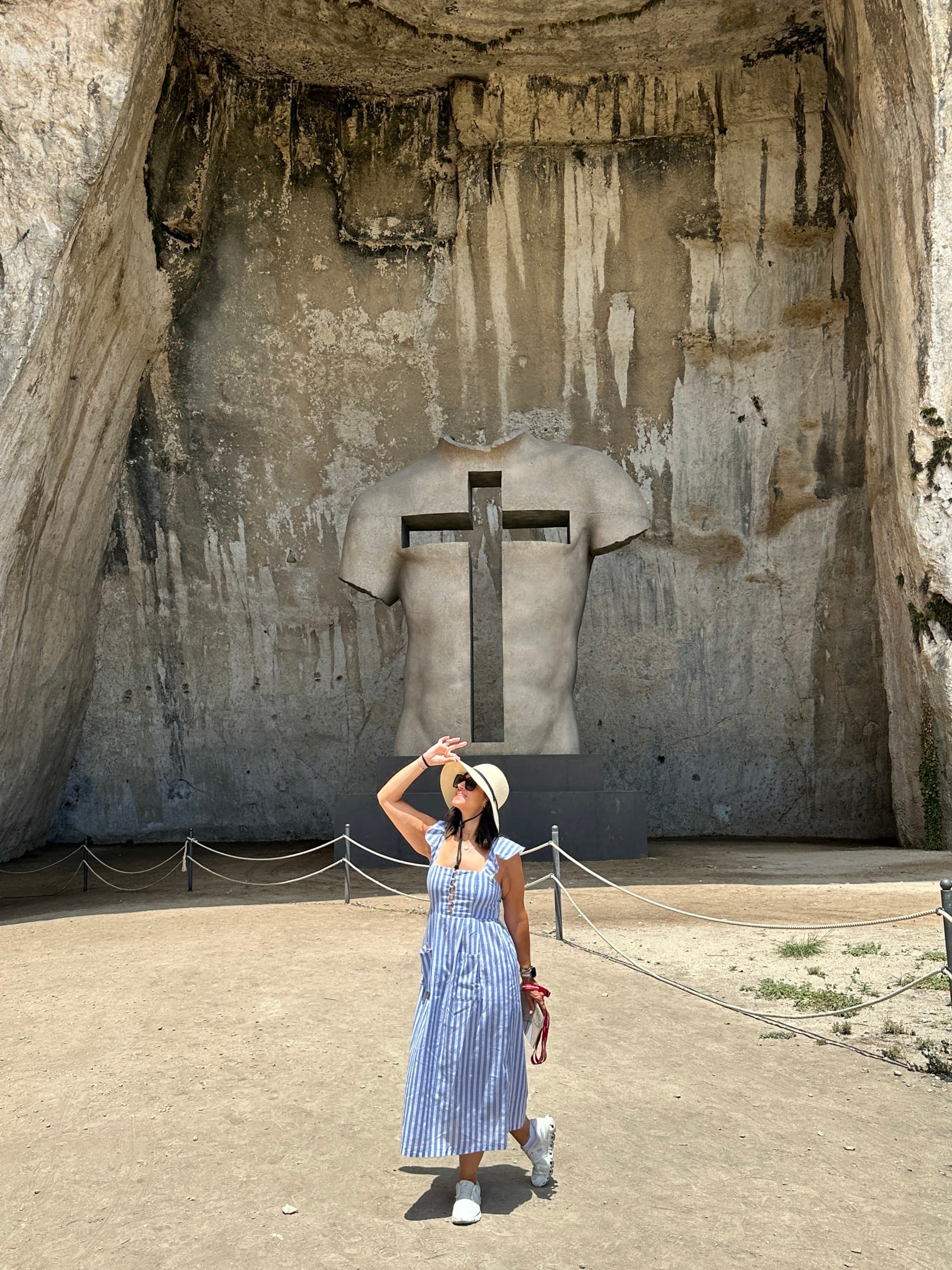 Advisor stands in front of a cave.