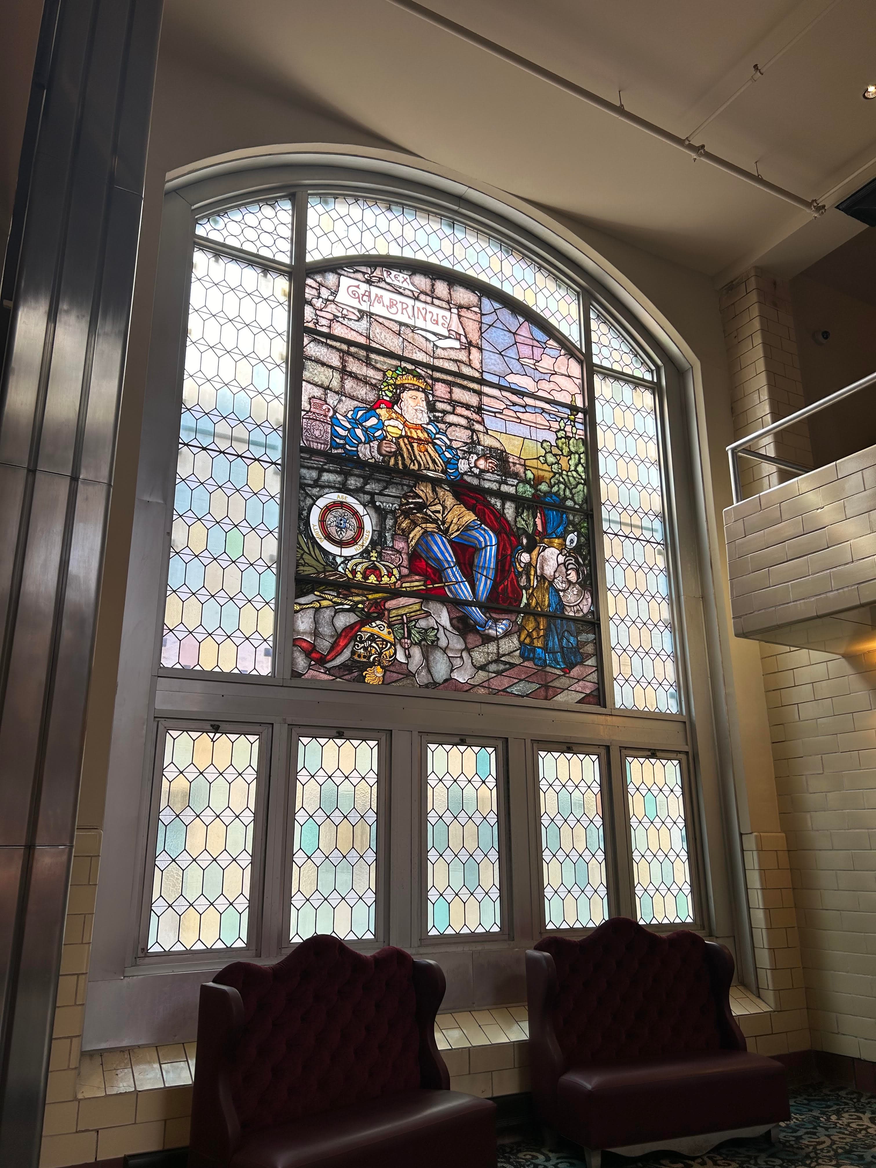 A view of a suite bed with bricked wall and window.
