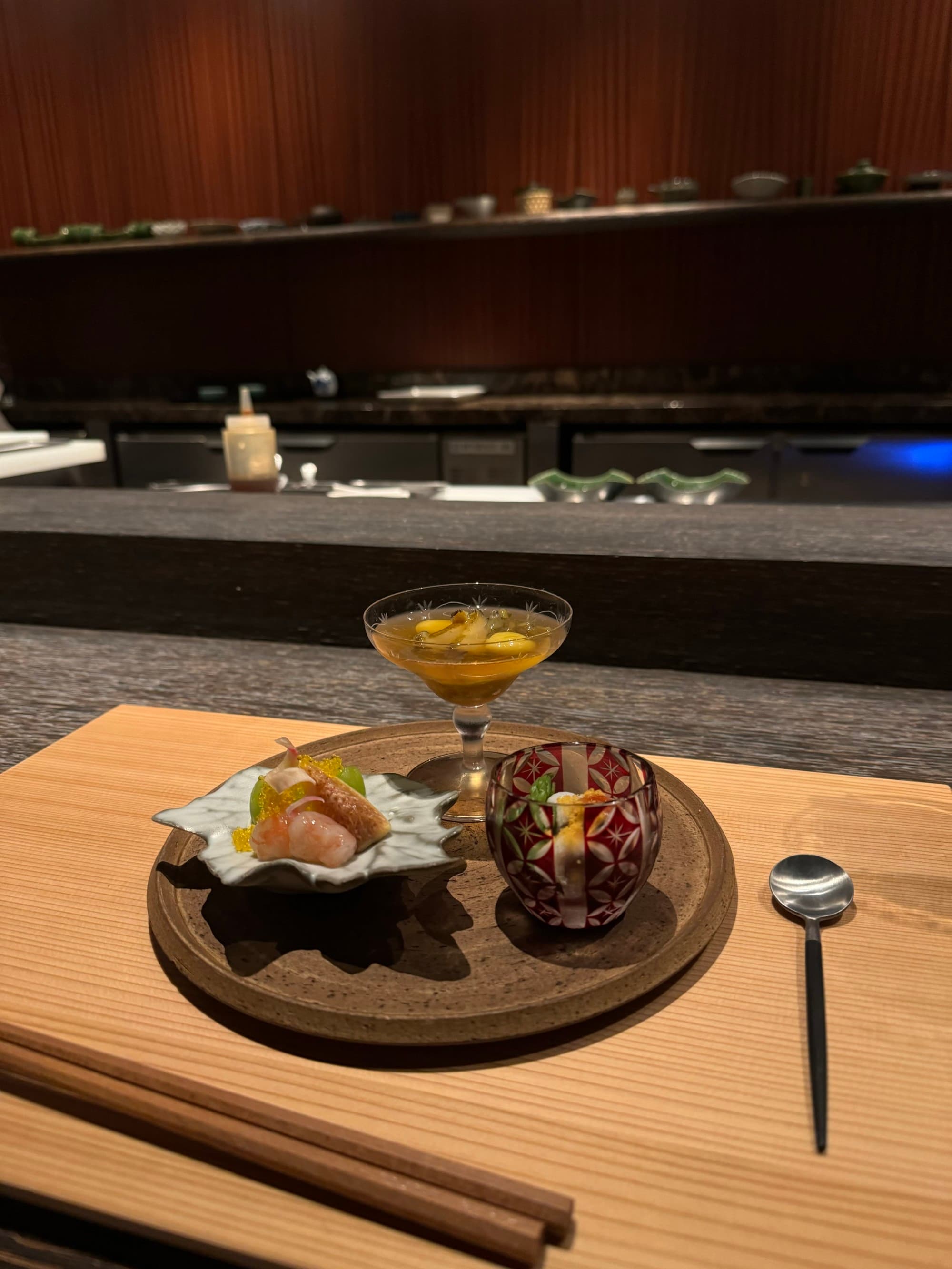 A view of food and a cocktail at the hotel restaurant with dark interior.