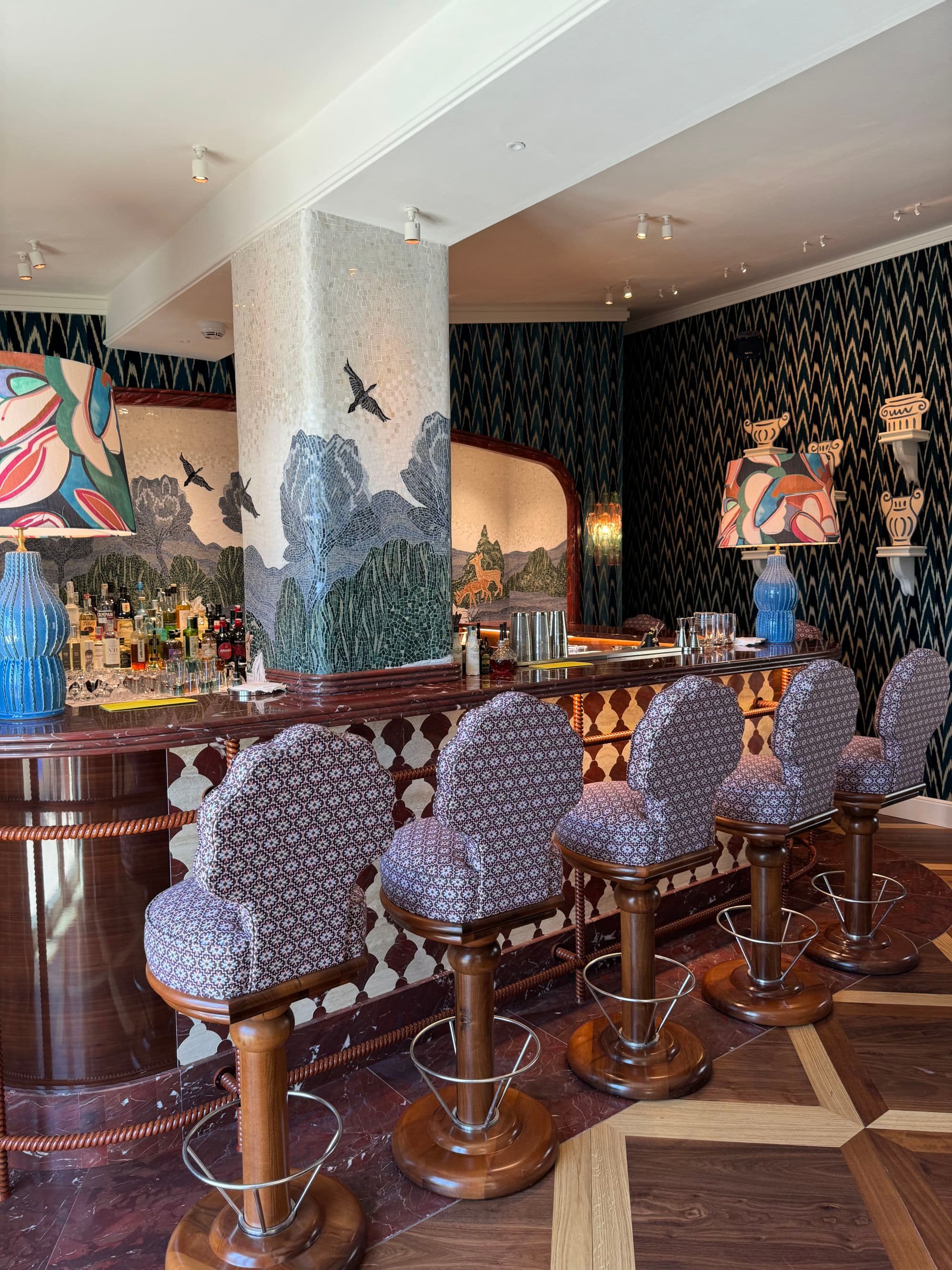 The hotel bar is bright and cheerful with fun patterns and rich wood furnishings.