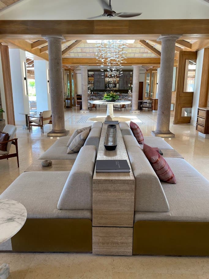 A lobby of a hotel with beige couches throughout