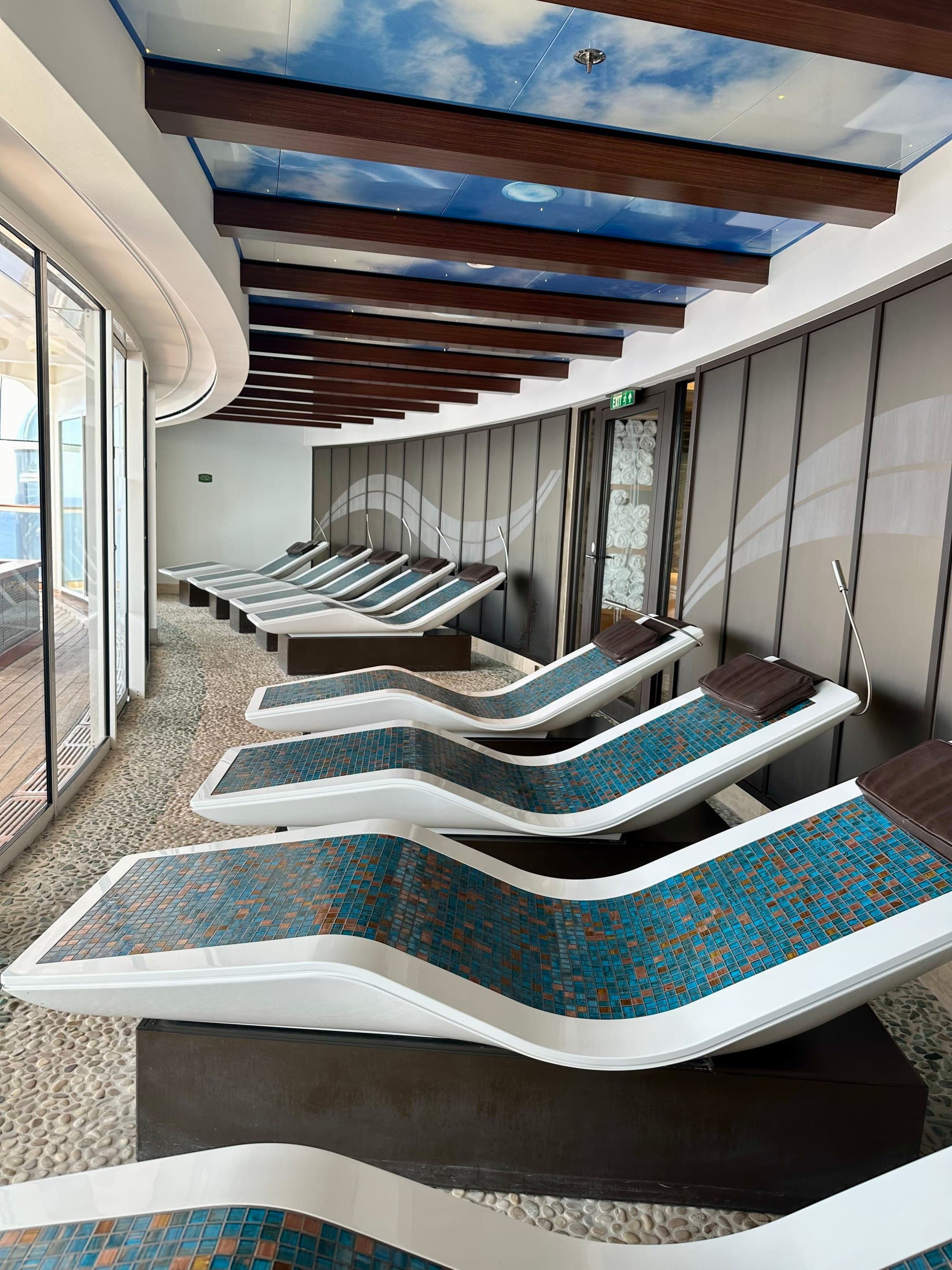 Heated lounge chairs beneath a blue sky with a few clouds.