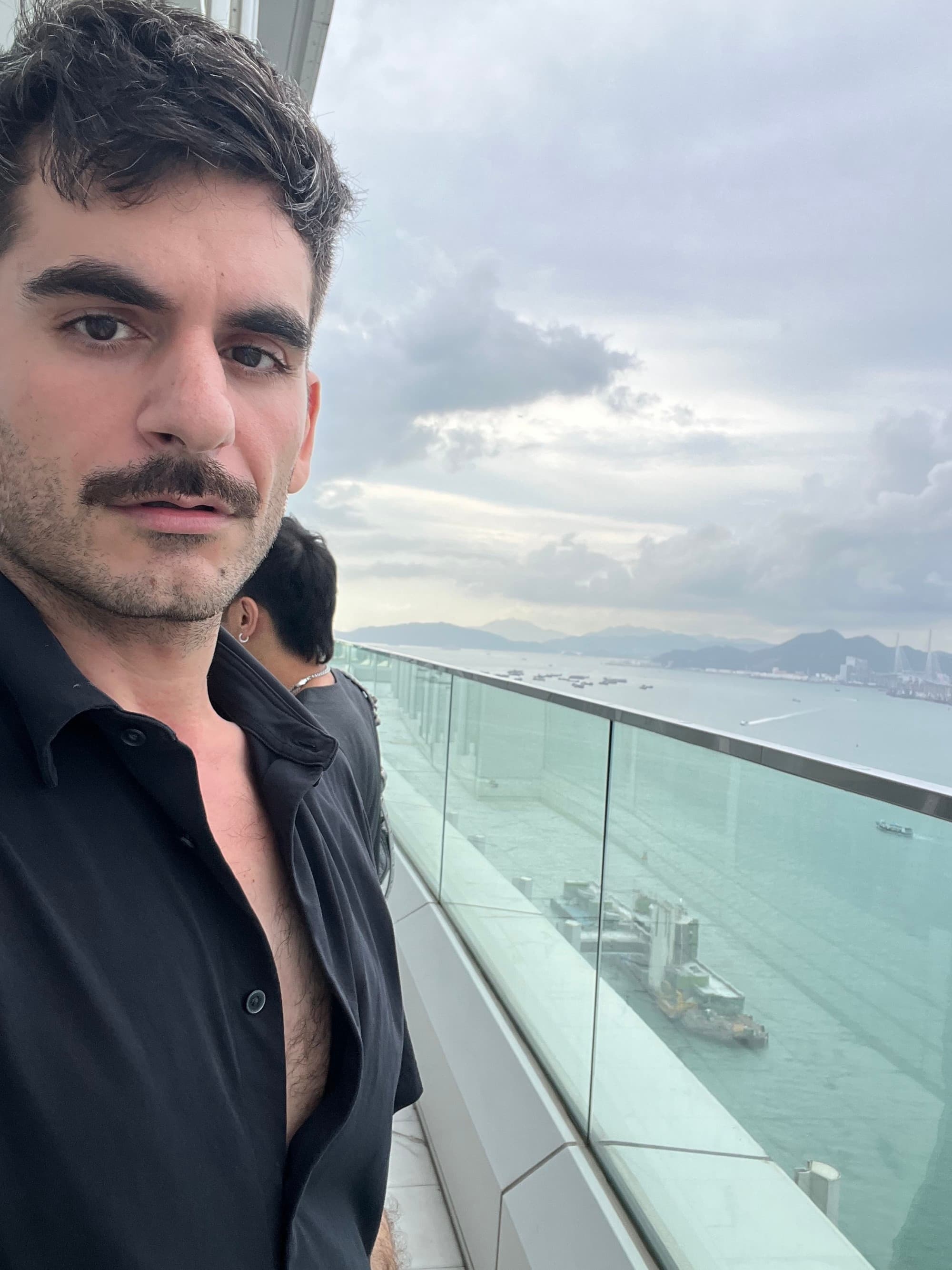 Advisor posing on the 45th-floor Executive Club Lounge with its expansive glass terrace offers incredible views on a cloudy day.