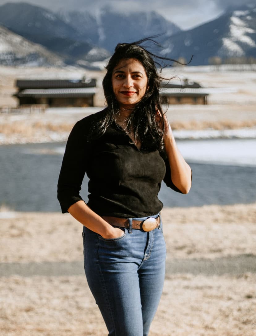 Fora Advisory Gaya Vinay standing in front of lodge and mountains.