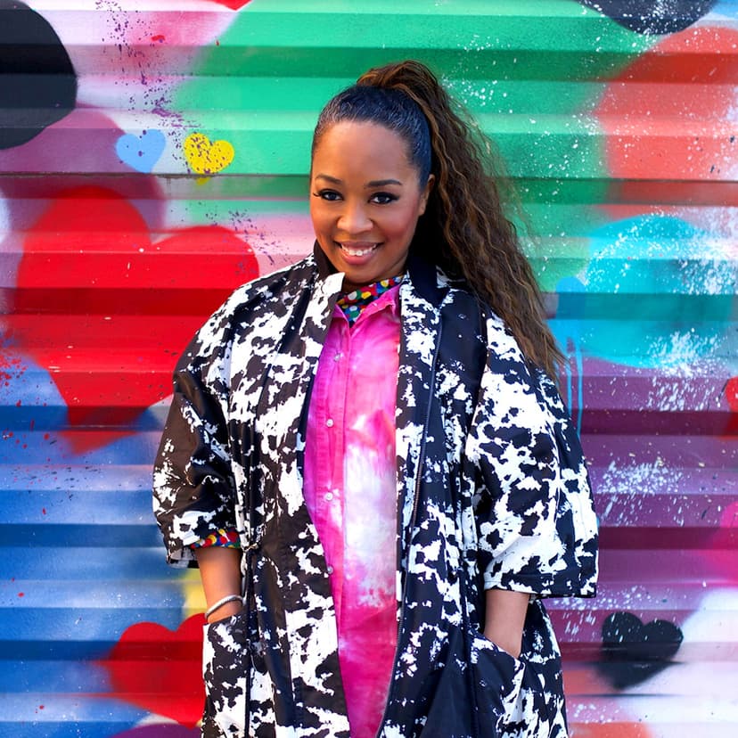 Fora Advisor Eunice Kindred leaning against wall with colorful street art.