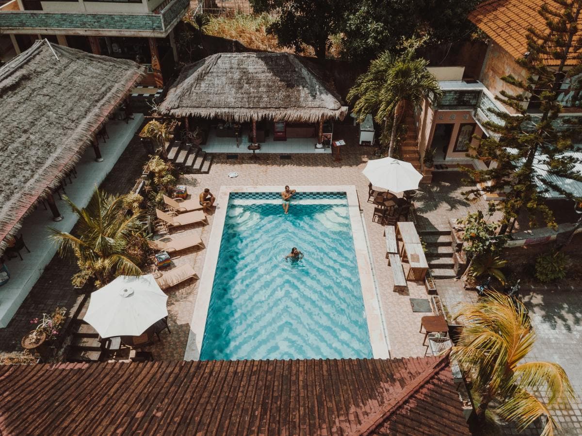 Woman and man lounging in pool of tropical resort.