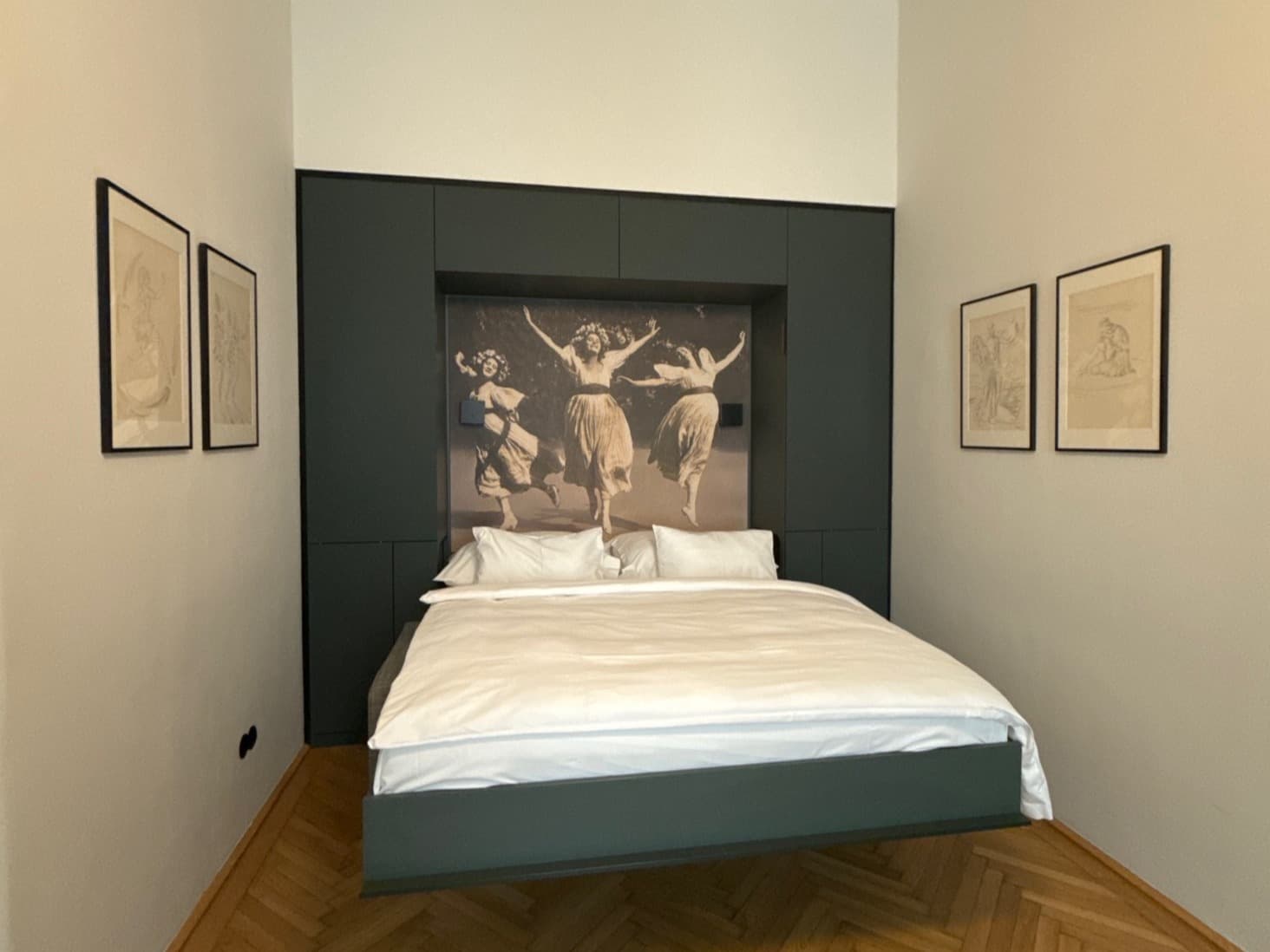 A bed in the center of a hotel room, pushed against a back wall with a large photograph above it