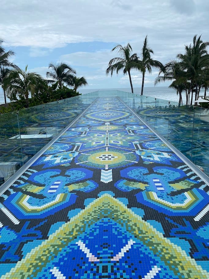 A mosaic laying under a pool area leading to the beach