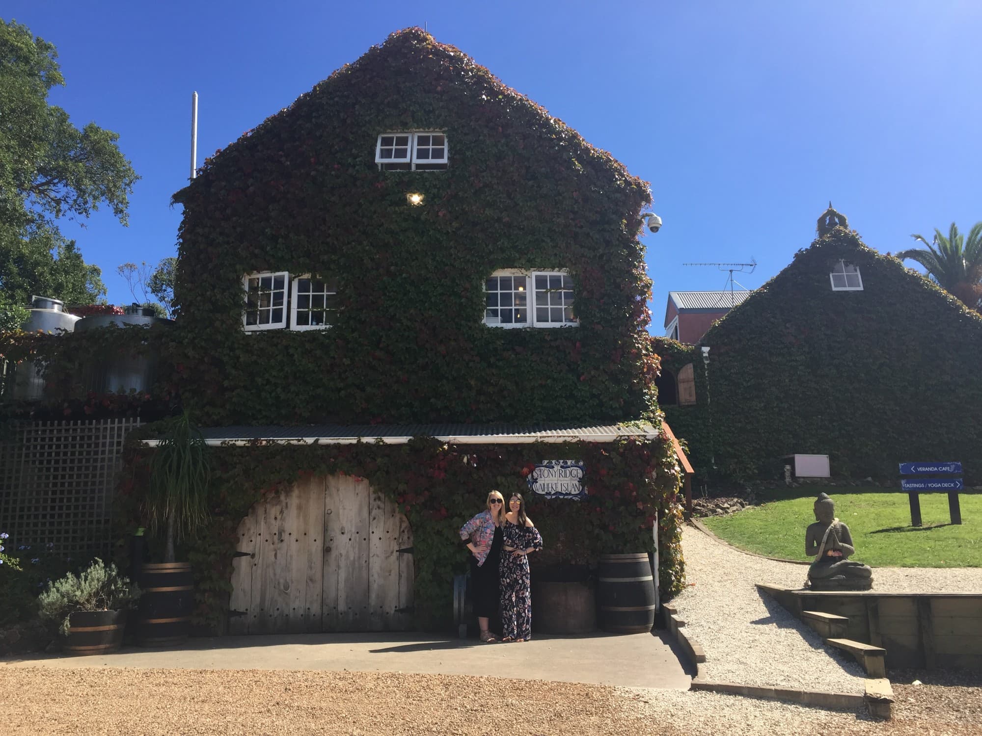 Couple posing in front of a vine-covered barn.
