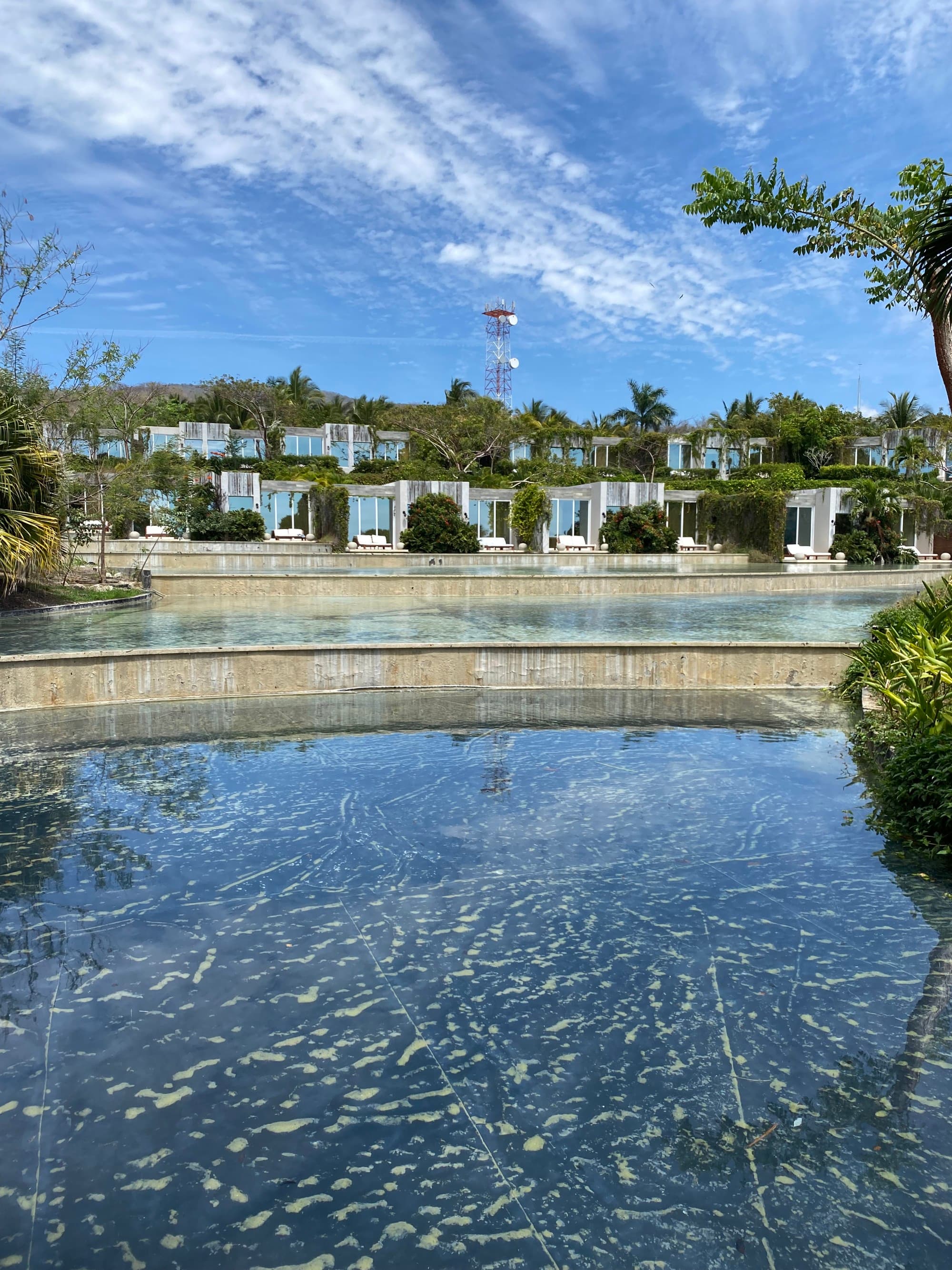 Pools of water in front of buildings under a blue sky