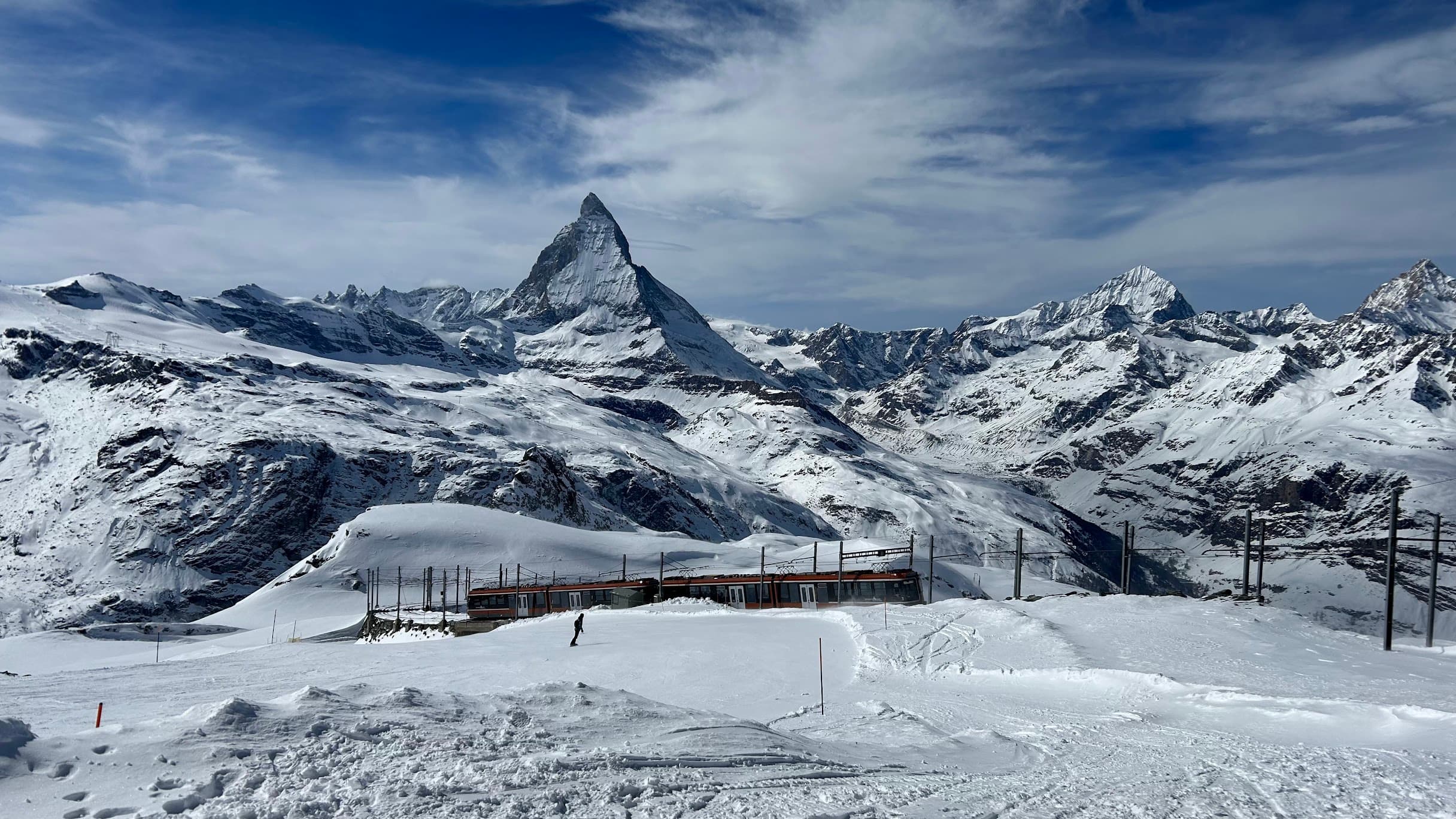 View of a snowy valley with ski trails and pretty white clouds